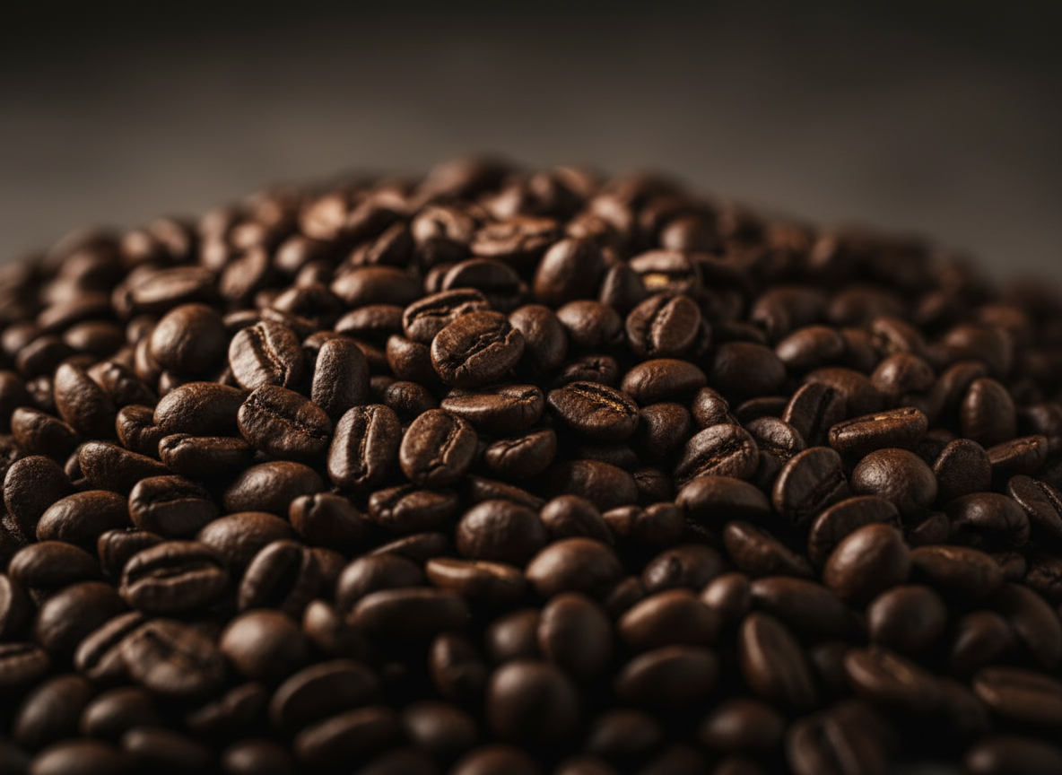 Extreme close-up of dark roasted coffee beans piled richly, dramatic low-key studio lighting
